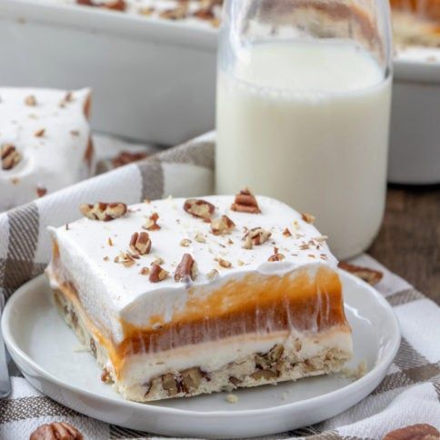 a piece of cake sitting on top of a plate next to a glass of milk