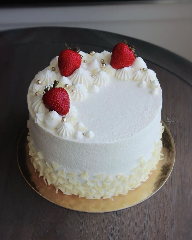 a cake with white frosting and strawberries on top