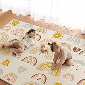 two babies are sitting on a play mat