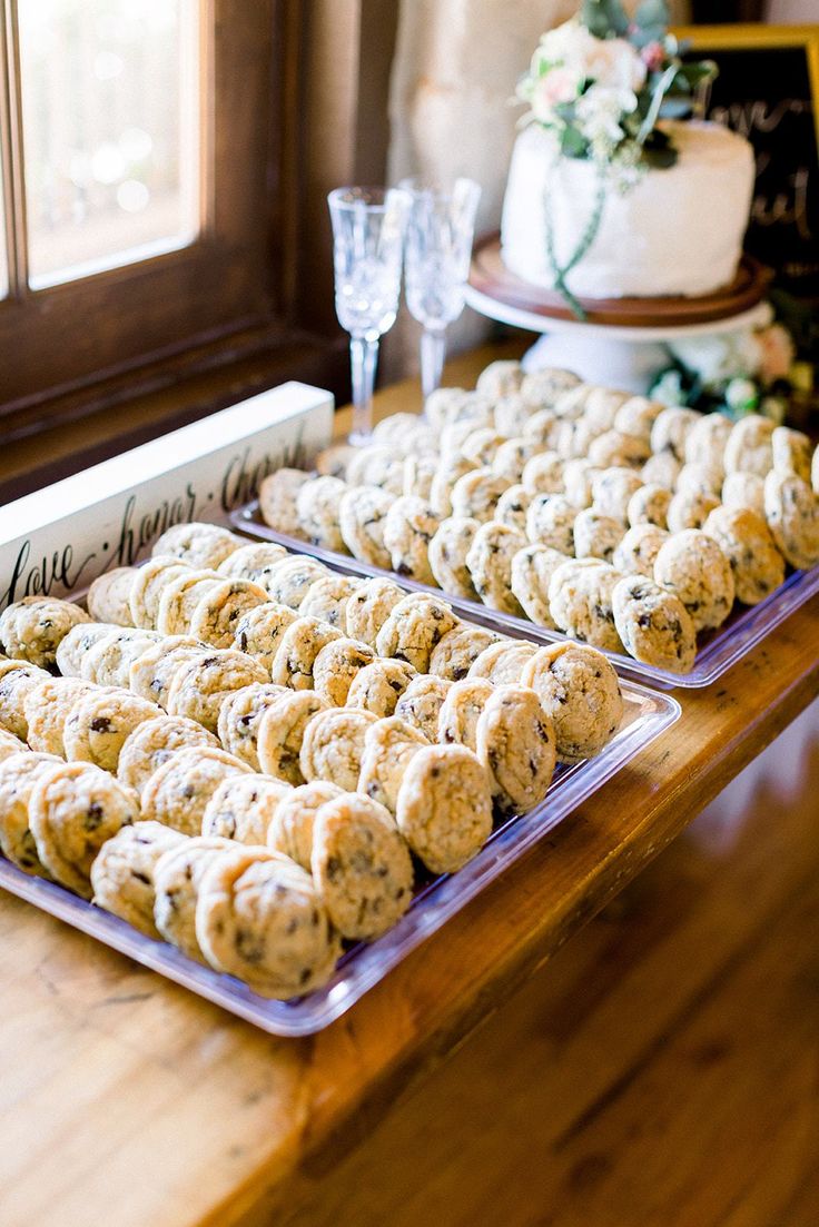 two trays filled with cookies on top of a wooden table