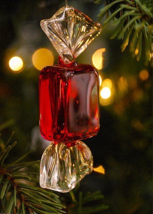 a red glass ornament hanging from a christmas tree