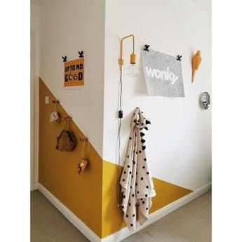 a yellow and white room with polka dot towels hanging on the wall next to a coat rack