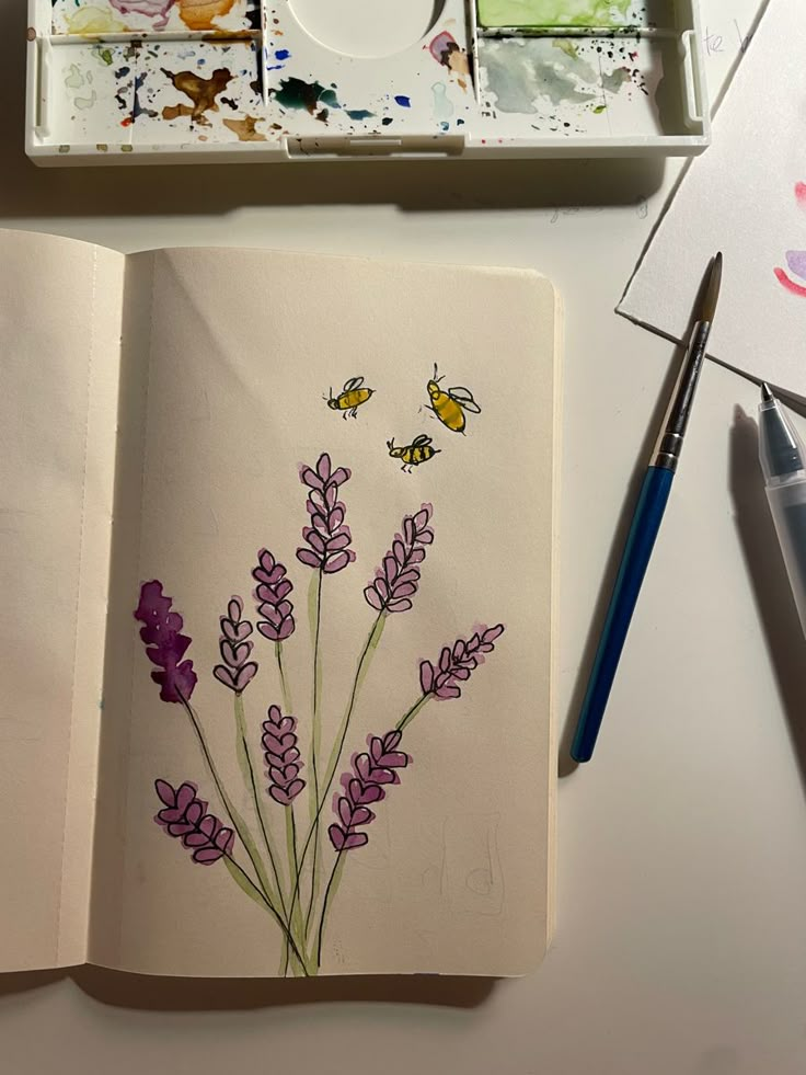 an open notebook with watercolors and flowers on it