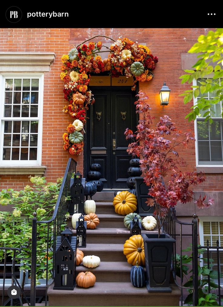 a front door decorated with pumpkins and gourds