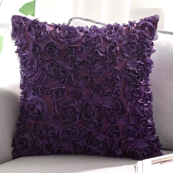 a white couch with a purple flowered pillow on it's back and side