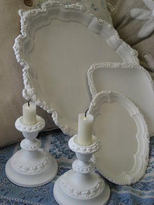 two candles are sitting next to an oval tray