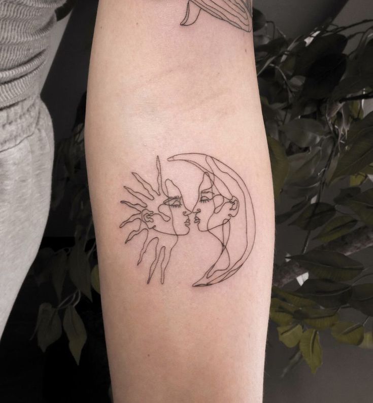 a woman's arm with a tattoo on it that has an image of two people kissing