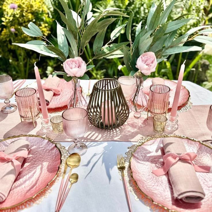 a table set with pink and gold place settings