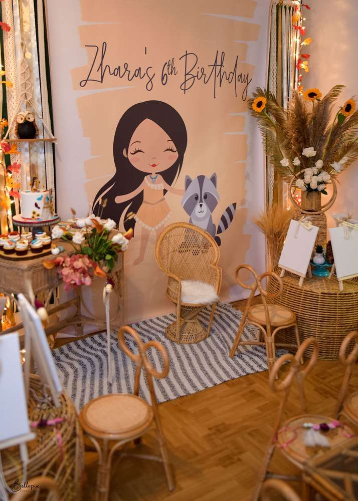 a room filled with wicker chairs and tables covered in flowers next to a birthday sign