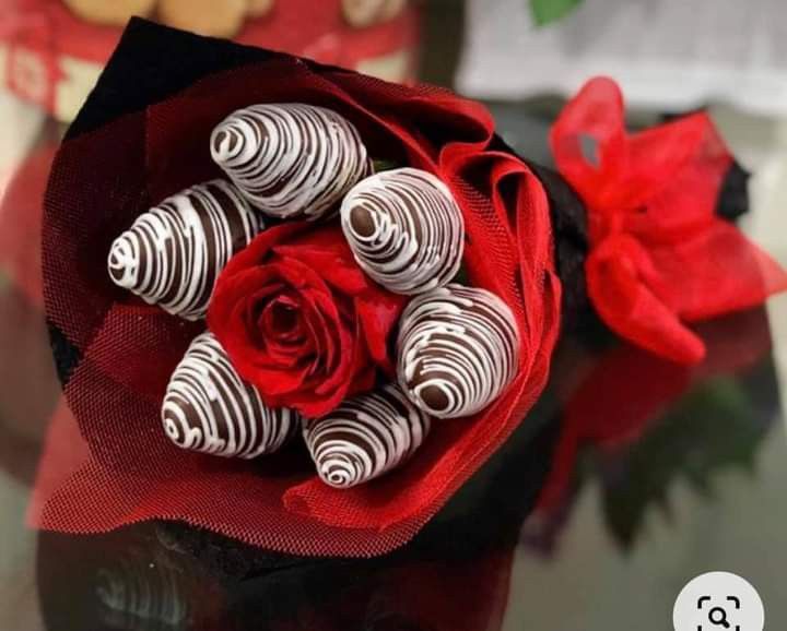 a bouquet of chocolates and a red rose on a table