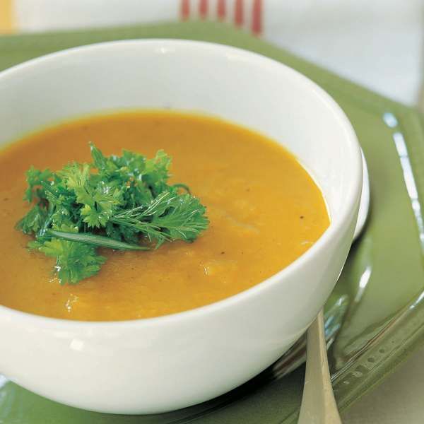 a white bowl filled with soup on top of a green plate