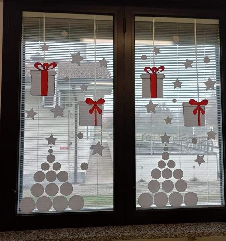 two windows decorated with red and white christmas decorations, one has presents on them while the other is wrapped in ribbon