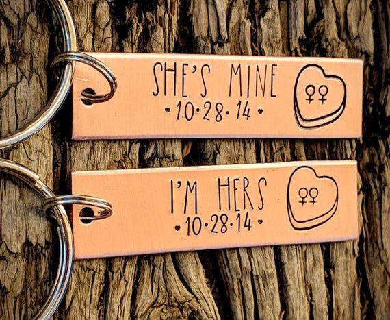 two metal key chains that say she's mine and i'm here