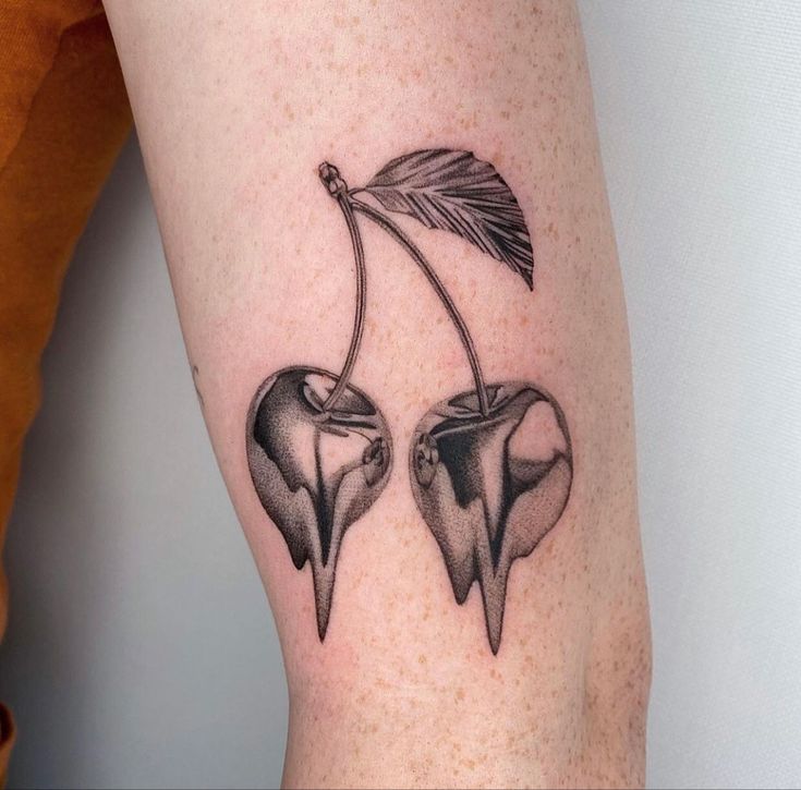 two cherries with an arrow on each side of the arm