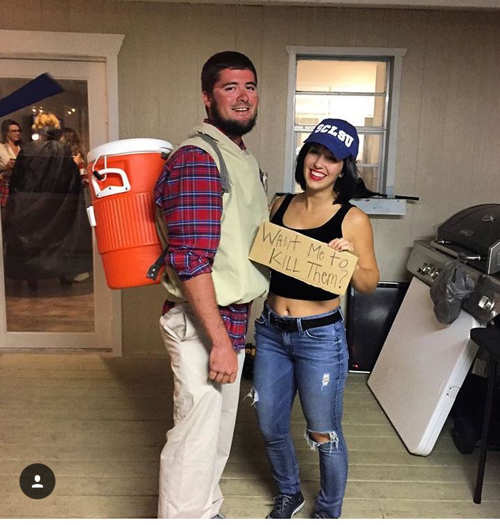 a man and woman standing next to each other holding signs