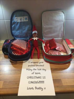 the elf is sitting in his suitcase and ready to go on vacation with his family