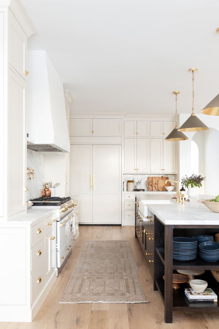 a kitchen with white cabinets and blue plates on the counter top, along with an area rug