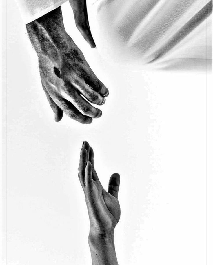 two hands reaching for each other in black and white