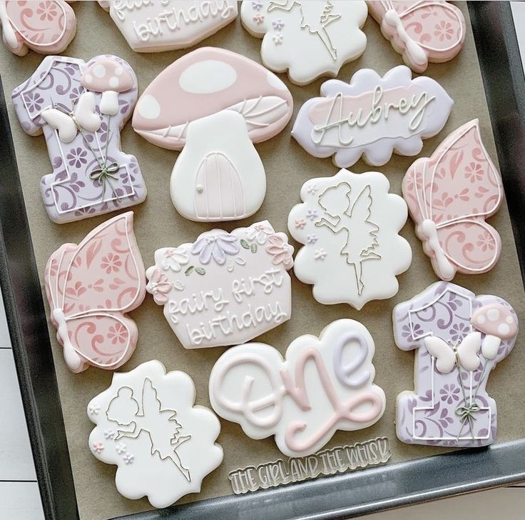 decorated cookies in the shape of baby's first birthdays on a cookie sheet