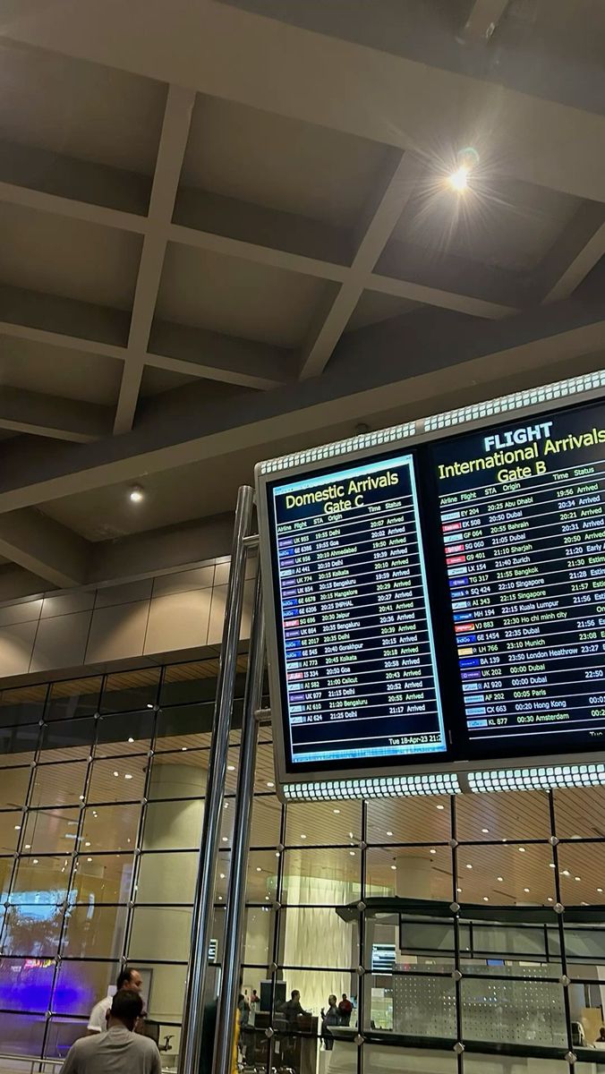 an airport terminal with people waiting for their luggage