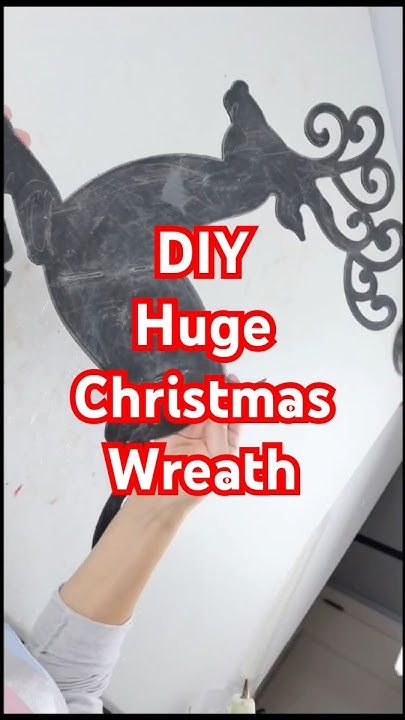 someone is holding up a sign that says diy huge christmas wreath on the wall