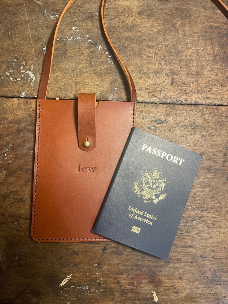 One of our favorite travel pieces!  No more digging through your bag when the friendly airport personnel tells you you're going to need to show your documents yet again.  Around your neck or over your shoulder, keep your passport and other important travel documents close by and organized with the Passport Pouch!   Don't forget to add FREE personalization! Dimensions: * 4.5" x 6.25" * back card pocket: 3.5" x 2.75" Travel Accessories With Cell Phone Pocket, Rectangular Travel Accessories With Cell Phone Pocket, Rectangular Travel Accessories With Cell Phone Pocket For On-the-go, Travel Phone Bag With Interior Card Slots, Rectangular Phone Bag With Card Slots For Travel, Brown Travel Phone Bag, Bifold Travel Accessories With Card Slots For Everyday Use, Rectangular Rfid Blocking Badge Holders For Everyday Use, Travel Accessories Pouch With Cell Phone Pocket