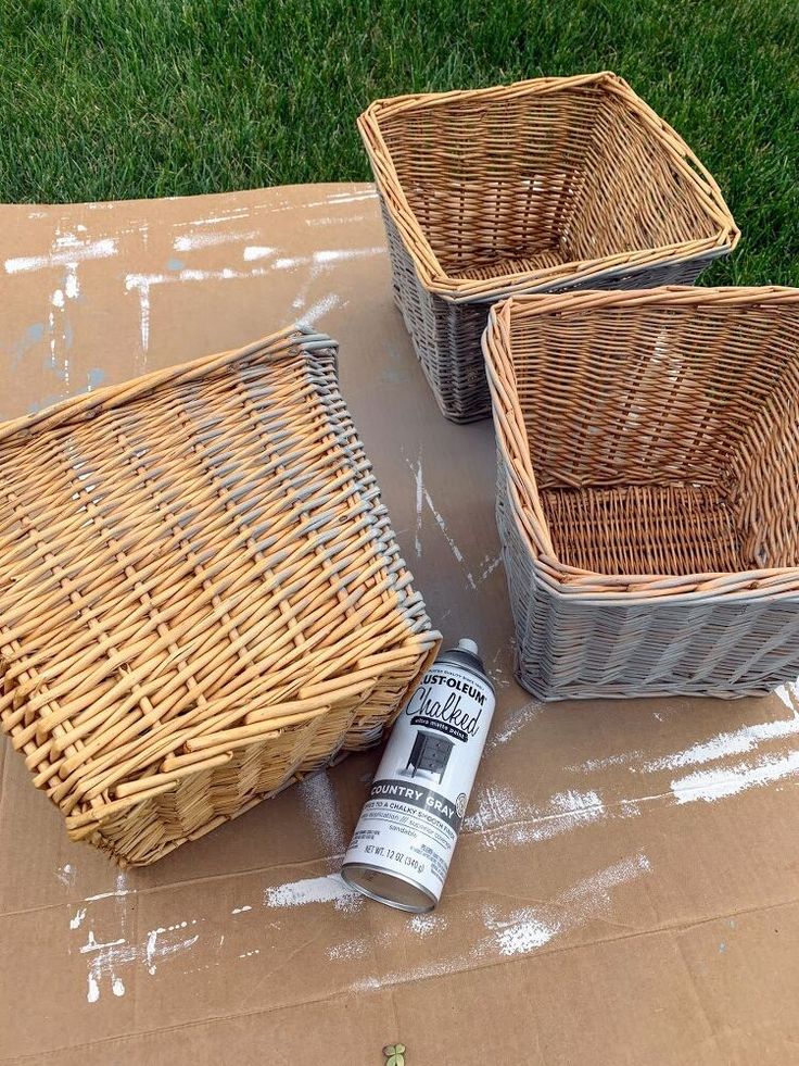 three wicker baskets sitting on top of a cardboard box next to a can of paint