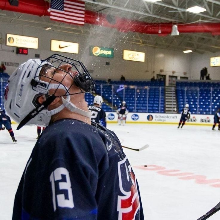 an ice hockey player is on the ice with his face mask up and looking at another player