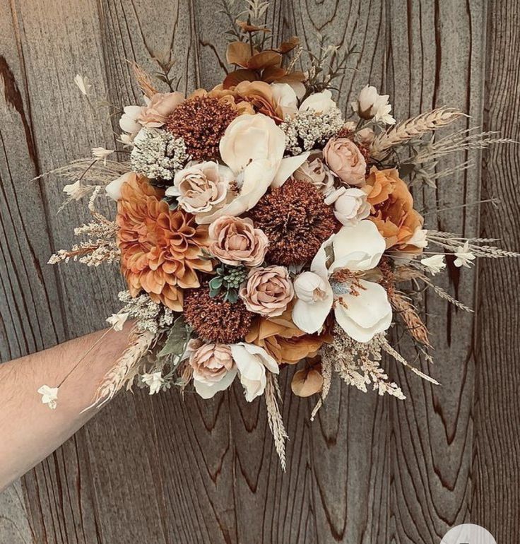 a person holding a bouquet with flowers on it