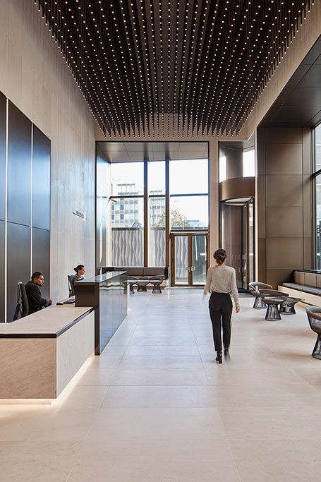 a woman walking down a hallway in an office building