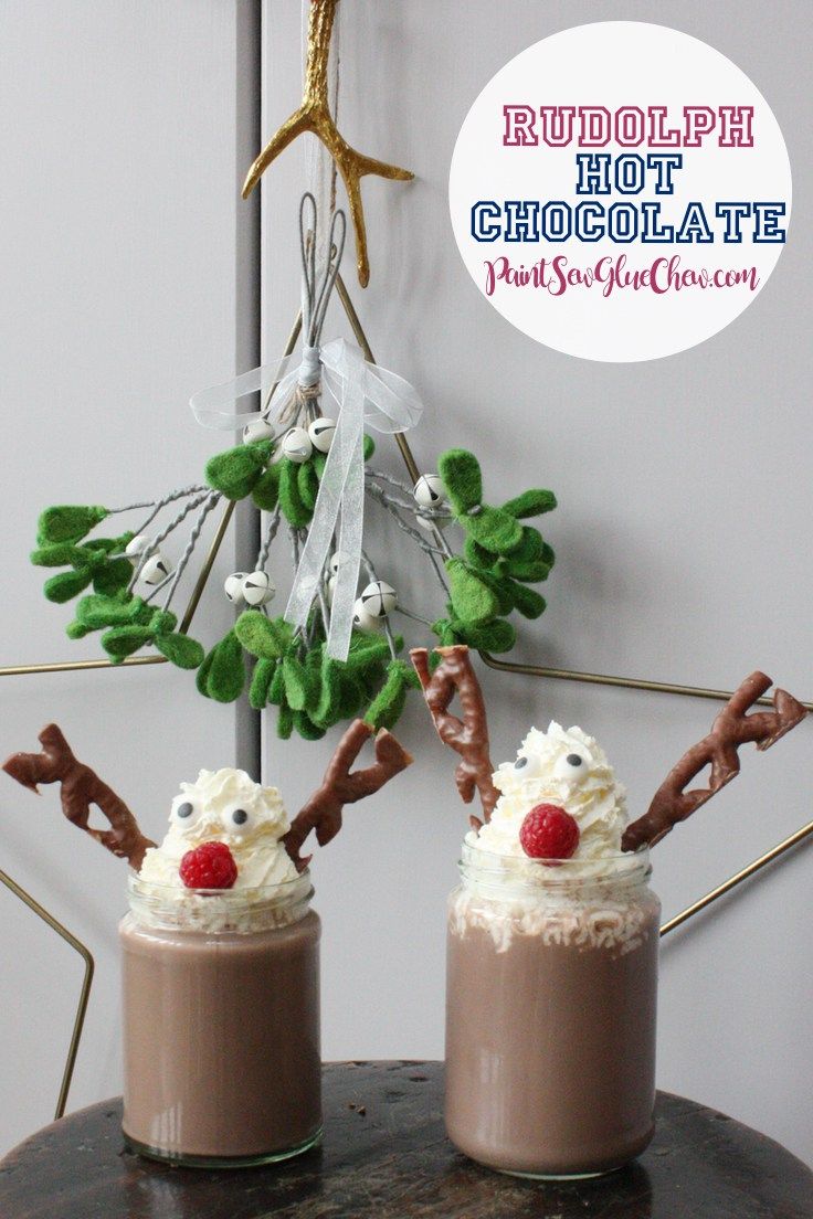 two cups filled with hot chocolate and topped with whipped cream, reindeer antlers and candy canes