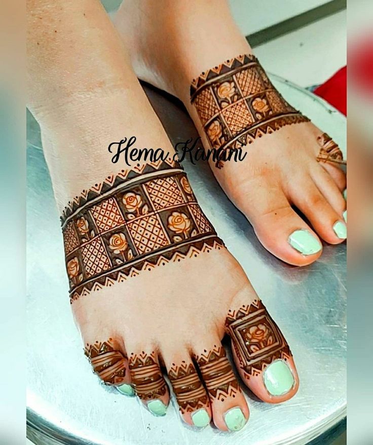 feet with henna tattoos on them sitting on a table