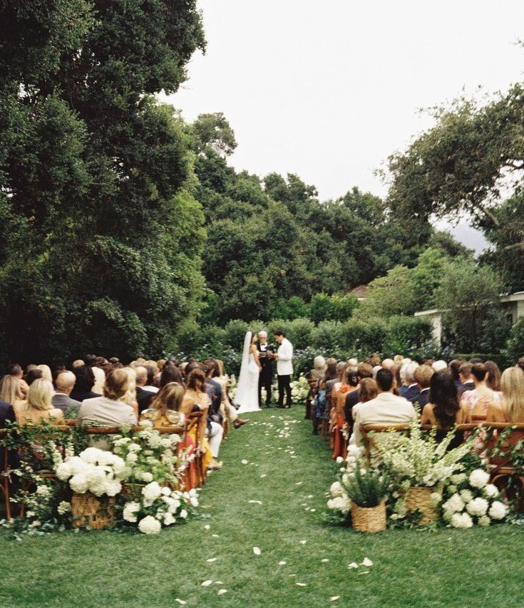 a wedding ceremony in the middle of a lush green field