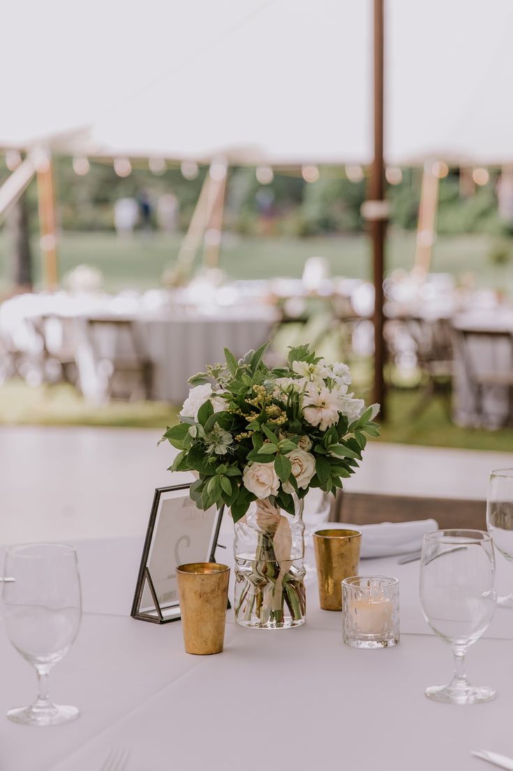 the table is set with flowers, candles and wine glasses for an elegant wedding reception