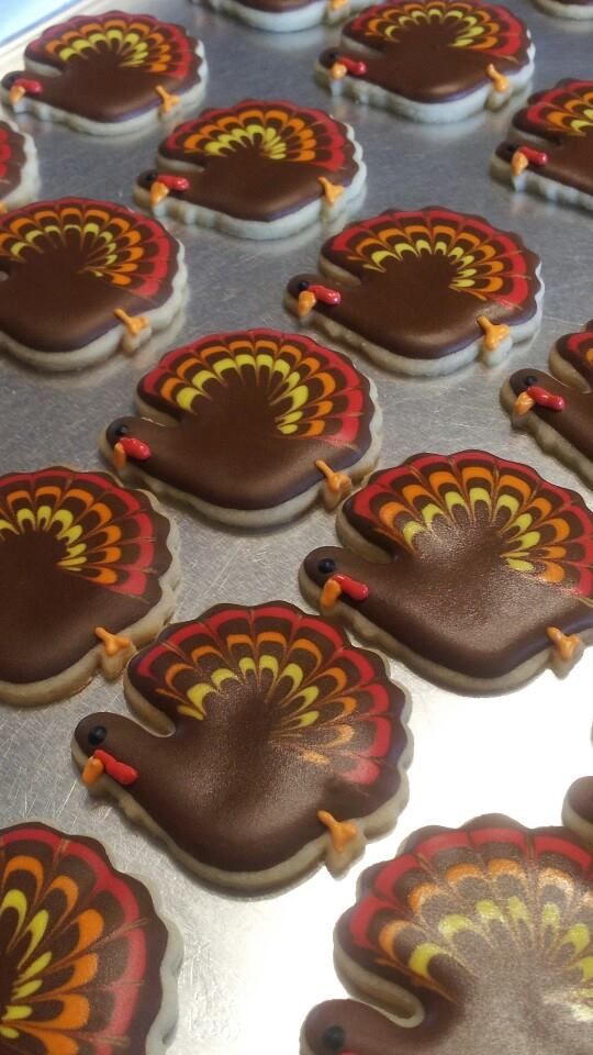 decorated cookies in the shape of turkeys are ready to be cut and put into baking tins