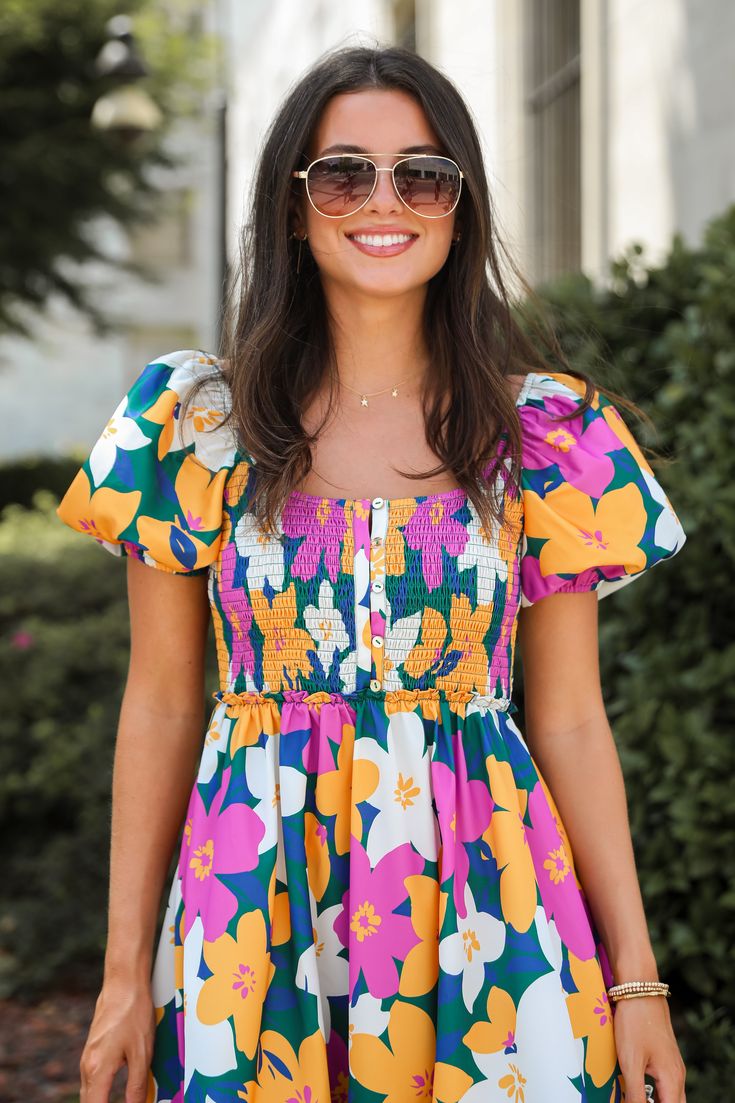 Grab your favorite sandals and hit the town for a good time in the Keep It Darling Magenta Floral Mini Dress! This dress is designed to showcase a lively array of floral patterns and a flattering silhouette, perfect for any sunny day outing or festive occasion. The dress features a captivating multicolored floral print that brings a burst of energy and joy to your wardrobe. The smocked bust adds a touch of texture and ensures a comfortable, form-fitting bodice that enhances your natural shape. P Multicolor Floral Printed Dress For Garden Party, Vibrant Print Floral Dress For Summer Garden Party, Vibrant Multicolor Floral Dress For Garden Party, Multicolor Floral Dress With Vibrant Print For Garden Party, Vibrant Floral Dress For Summer Garden Party, Colorful Floral Print Dress For Garden Party, Spring Multicolor Floral Dress With Ditsy Print, Multicolor Floral Dress With Vibrant Print For Day Out, Casual Summer Floral Dress With Vibrant Print