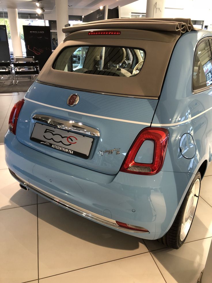 the back end of a blue car in a showroom