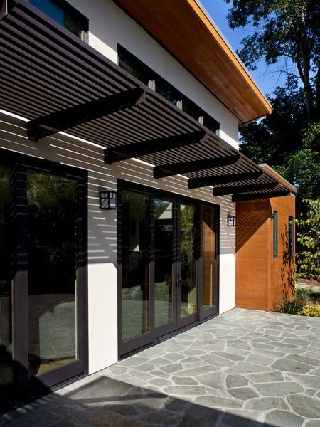 the outside of a house with an awning and stone walkway leading up to it