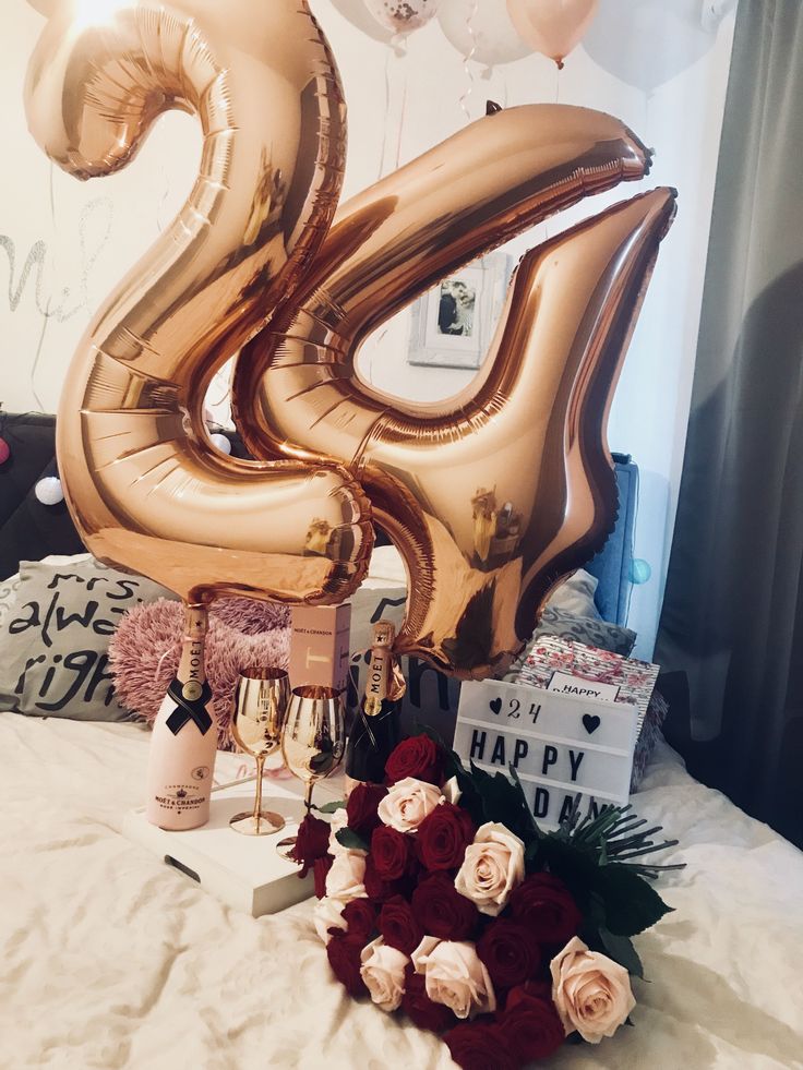 the number twenty five balloon sits on top of a bed with roses and other decorations