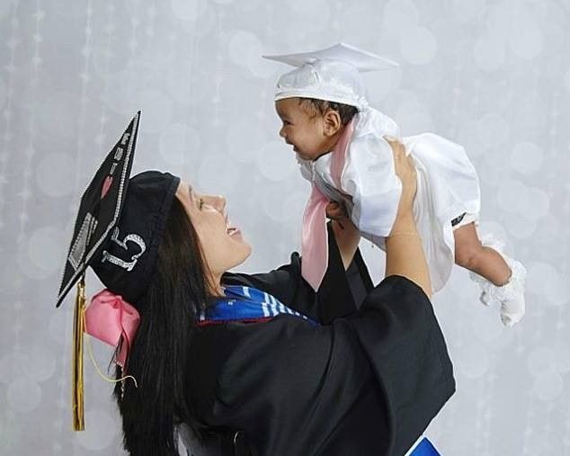 a woman holding a small child in her arms while wearing a graduation cap and gown