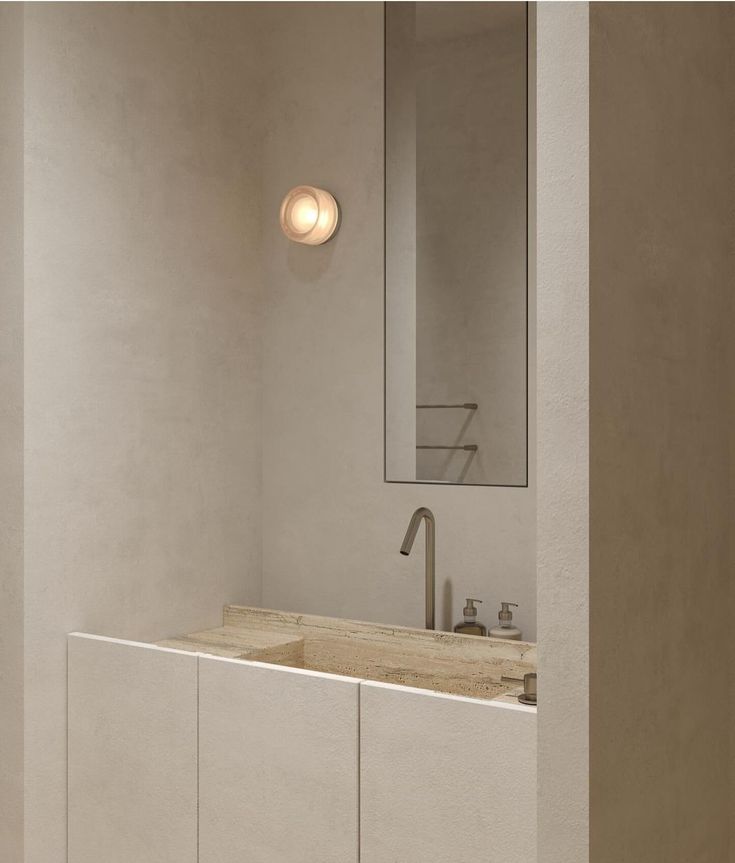 a bathroom with a sink and mirror next to a wall mounted faucet in the corner