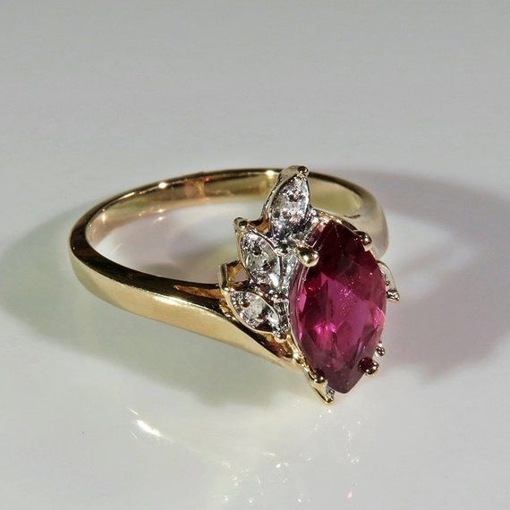 A beautiful large fine earth mined natural purple sapphire and diamond engagement ring circa 1970 handmade in solid 14K yellow gold and set with sparkly fine white diamond accents. This stunning ring is set with a rare purple sapphire which has a unique purple pink color. It's a gorgeous gem which would be hard to ever replace due to the amazing shade of purple of the fine sapphire. I adore the pretty asymmetrical setting with it's delicate splash of diamond accents. It is in excellent condition Classic Marquise Ruby Ring With Vvs Clarity, Heirloom Ruby Ring With Diamond, Elegant Marquise Ruby Ring With Vvs Clarity, Classic Marquise Ruby Ring With Brilliant Cut, Vintage Diamond Ruby Ring, Heirloom Ruby Ring With Brilliant Cut For Anniversary, Heirloom Style Ruby Ring With Brilliant Cut For Anniversary, Heirloom Brilliant Cut Ruby Ring For Anniversary, Heirloom Marquise Ruby Jewelry