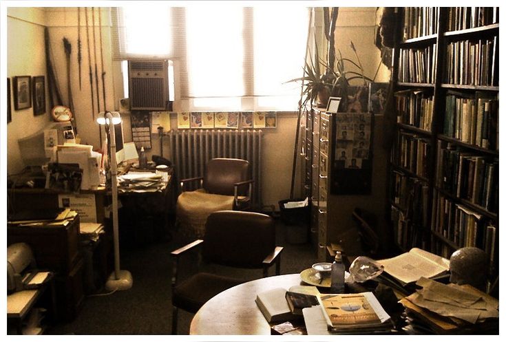 a room filled with lots of books and furniture next to a tall bookcase full of books