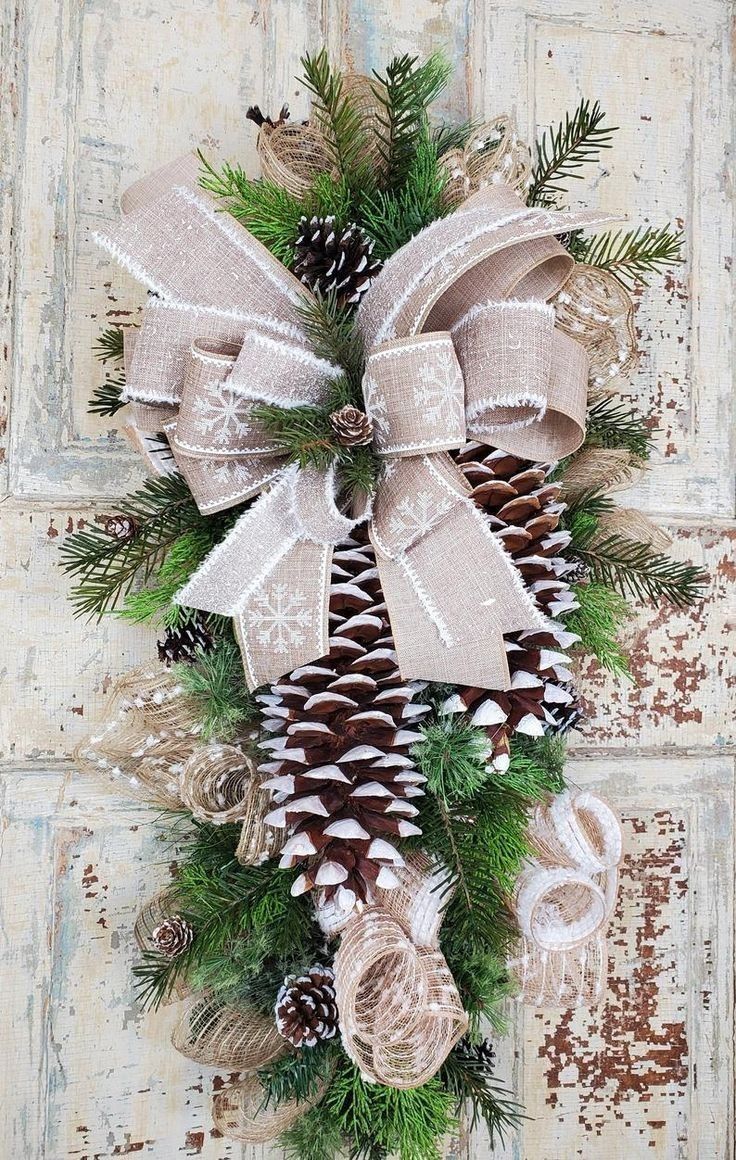 a christmas wreath with pine cones and bows