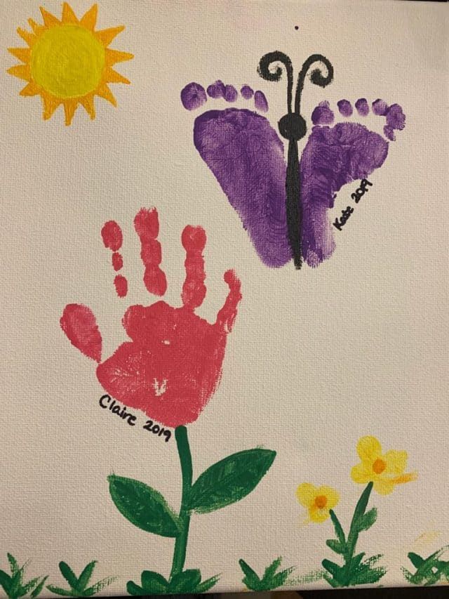 handprints with flowers and butterflies on white paper