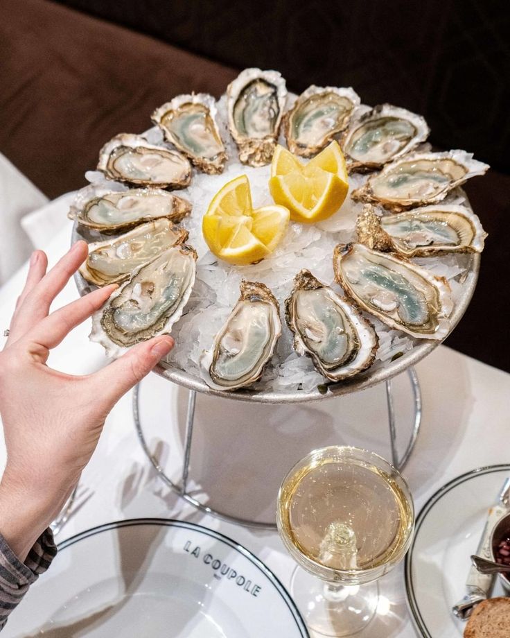 a platter filled with oysters and lemon wedges