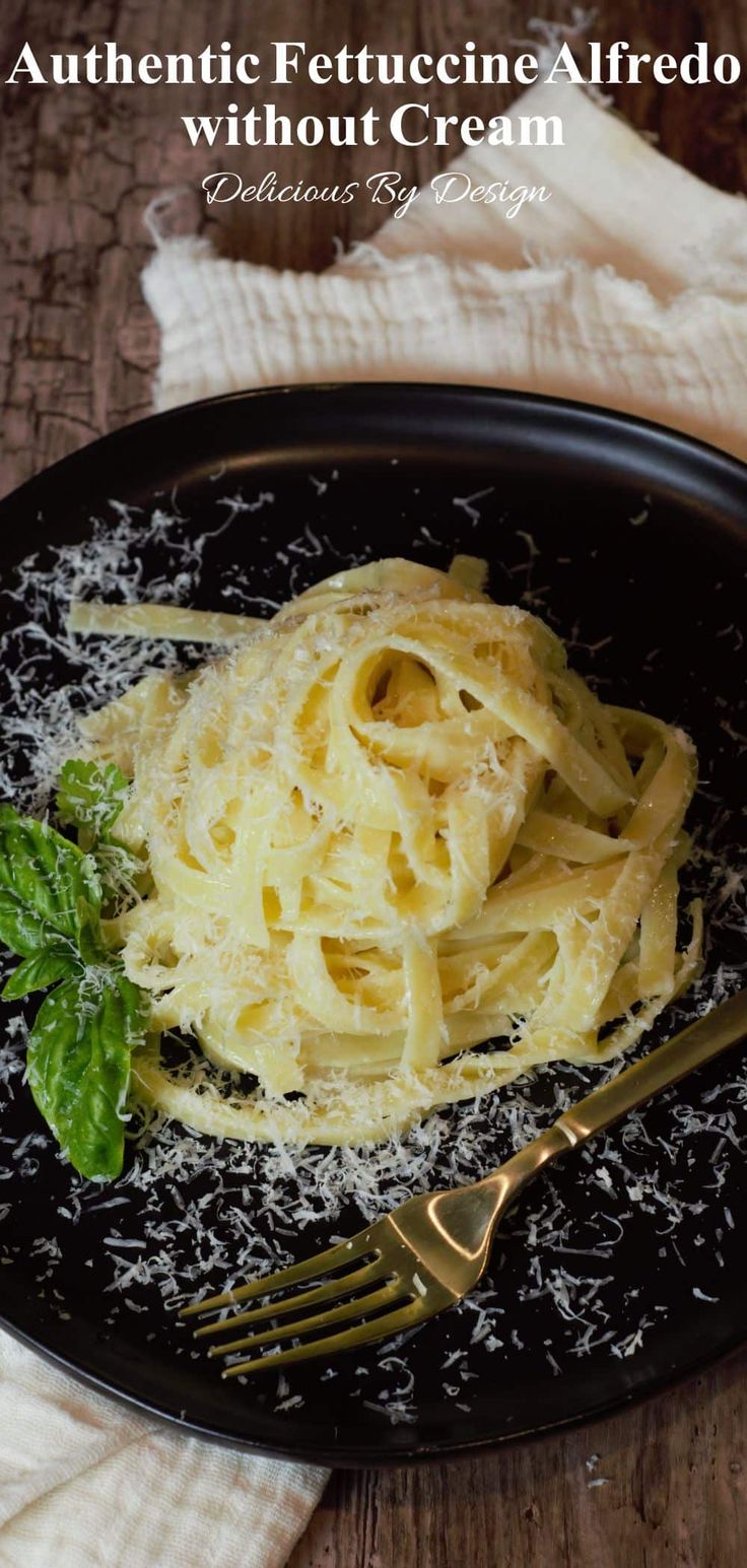 a black plate topped with pasta and parmesan cheese