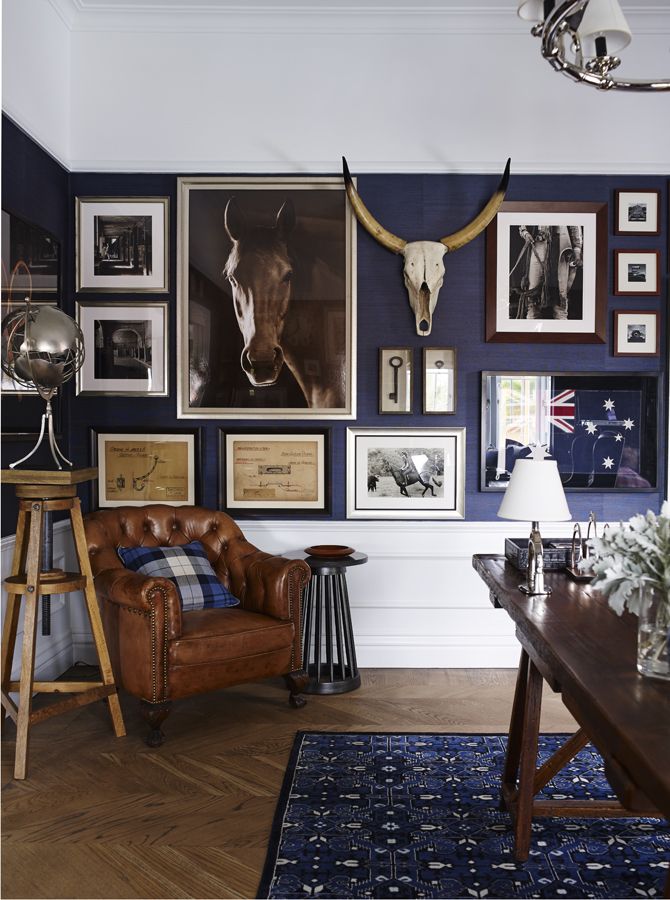 a living room filled with furniture and pictures hanging on the wall above a wooden table