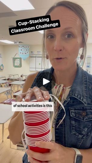 a woman holding stacks of red and white plates in front of her face with the caption cup - stacking classroom challenge