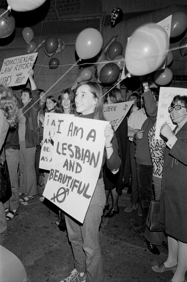 a group of people holding signs and balloons